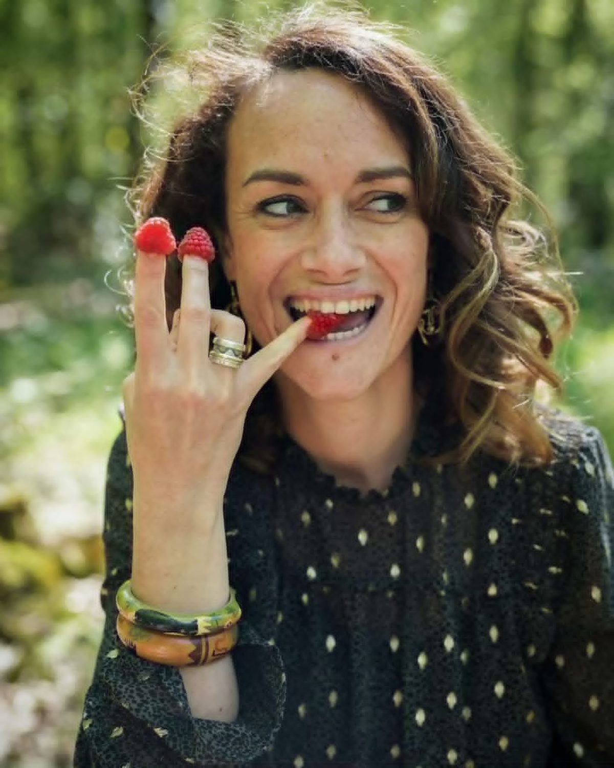 Marie-Astrid souriante, des framboises au bout des doigts